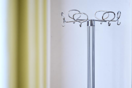 H6 – Sitzungszimmer 101 – Kleiderständer Chromstahl, gelber Vorhang links im Bild.